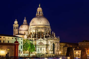 Fototapeta na wymiar Ornate facade of the Santa Maria della Salute Church, Venice, illuminated at night, built by the Ventians to offer thanks for surviving the Plague