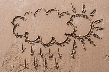 sun with cloud drawing on beach sand