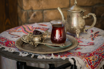 Tea set in oriental style in pear shaped glass with vintage kettle and dates fruit