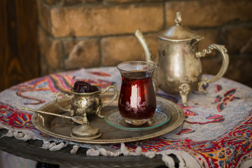 Tea set in oriental style in pear shaped glass with vintage kettle and dates fruit