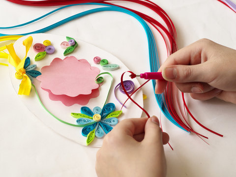 Decorate with strips of paper, quilling .Hands child while creative work making decorations by quilling paper