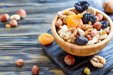 Nuts and dried fruit in a wooden bowl.
