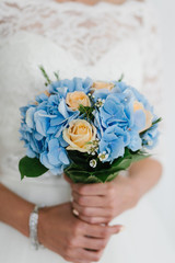 beautiful blue and yellow fresh flowers wedding bouquet. Bride with wedding bouquet, closeup