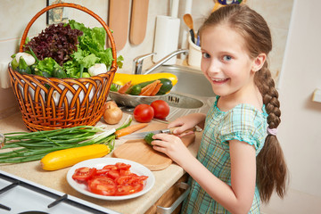 girl chopping cucumber in kitchen, vegetables and fresh fruits in basket, healthy nutrition concept