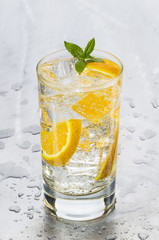 szklanka zimnej wody mineralnej z pomarańczą
