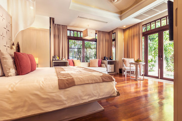 Luxury bedroom hotel interior, big window, terrace, sofa, wooden floor