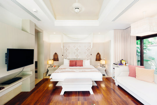 Luxury bedroom hotel interior, TV, sofa, wooden floor