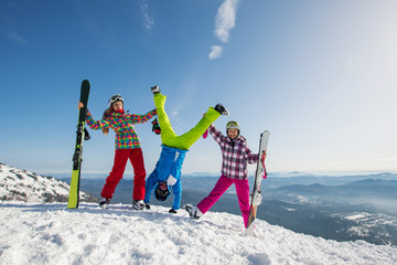 Happy friends having fun playing in snow, Man standing on his hands. Ski and snowboard holiday