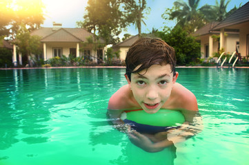 teenager boy in open air swimming pool in asian hotel bungalow resort