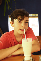 teen boy dring milk shake coconut cocktail close up photo