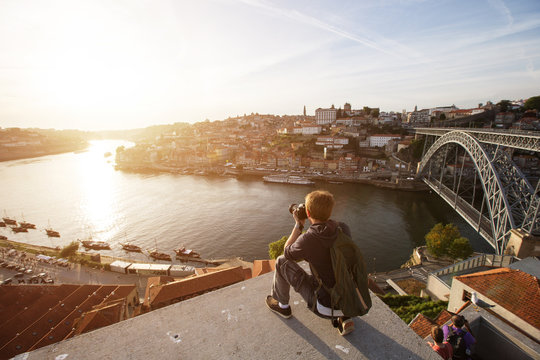 Travel photographer doing pictures of sunset above river in Porto, Portugal. Europe traveling
