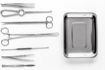 Surgical instruments and tools including scalpels, forceps and tweezers on white table top view...