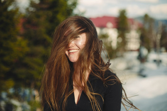 Portrait of magnificent smiling woman with ling brown hair outdoor