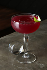 Red cocktail with a ice cub. Close up