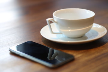 Empty cup and mobile phone. Close up