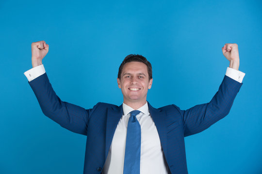 man smiling with winner gesture in fashionable suit