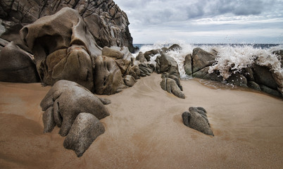Fototapeta na wymiar Wave splash on beach with heart rocks