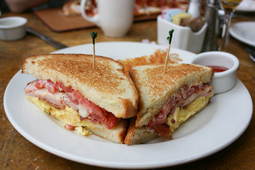 Eggs, bacon and cheese breakfast sandwich with hash brown potatoes, close up, lifestyle, horizontal