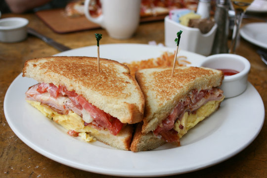 Eggs, Bacon And Cheese Breakfast Sandwich With Hash Brown Potatoes, Close Up, Lifestyle, Horizontal