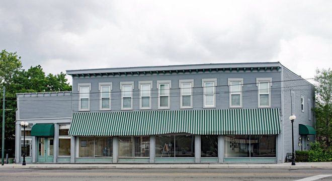 Old, Historic Business Building With Green Striped Awning
