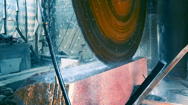 Bridge saw machines cutting granite block in slow motion
