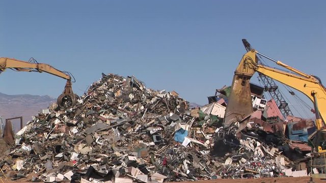 Crane moving piles of scrap metal in Junk Yard