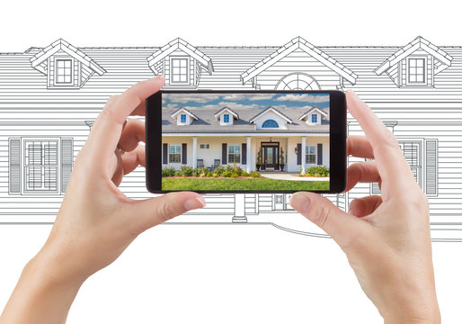 Hands Holding Smart Phone Displaying Home Photo of Drawing Behind