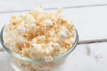 Popcorn in glass bowl on white table
