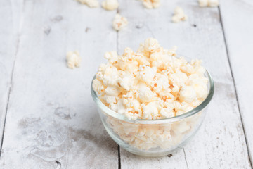 Popcorn in glass bowl on white table