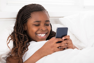 Girl In Bed Using Cell Phone