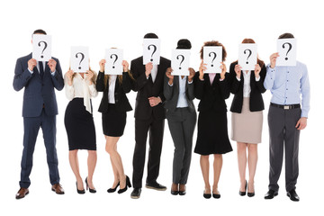 Obraz premium Businesspeople Hiding Behind Question Mark Sign