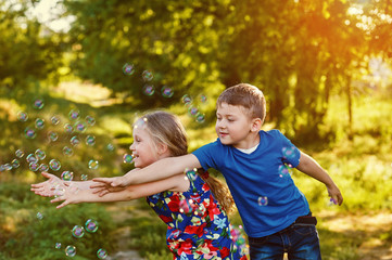 Children play with soap bubbles in the Park at sunset