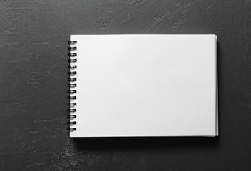 Blank sketchbook with white pages isolated on black background