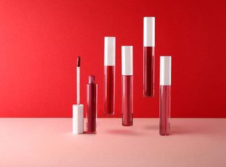 Set of decorative cosmetics/lip gloss on light colorful background.