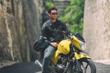 Fototapeta na wymiar Modern handsome man posing with his motorbike.