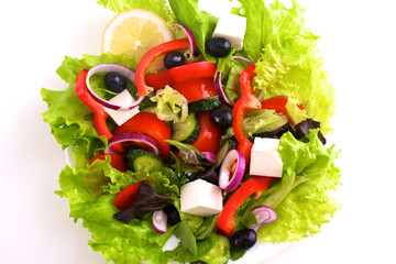 salad from fresh vegetables in a plate on a table, selective focus