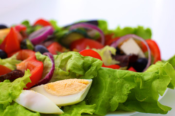 salad from fresh vegetables in a plate on a table, selective focus