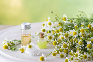 Obraz na płótnie Canvas Body care cosmetic products with camomile and camomile flowers