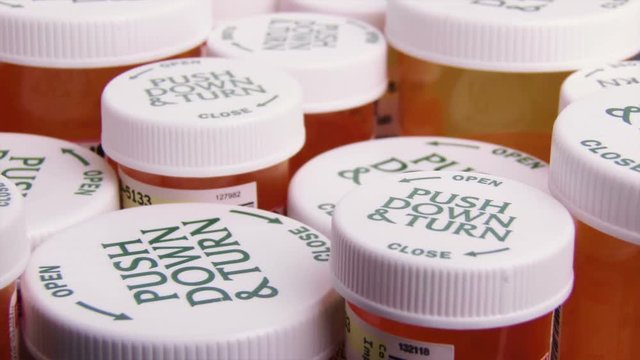 Slider shot of many prescription bottles, close-up