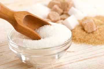 white and brown sugar on wooden background