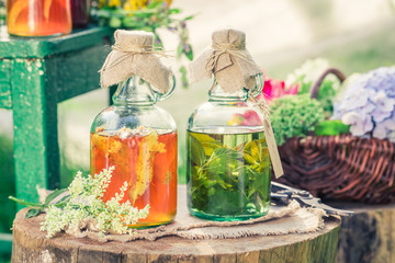 Healing herbs in bottles with herbs and alcohol in summer
