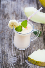 Yogurt and smoothie with melon on a wooden table.