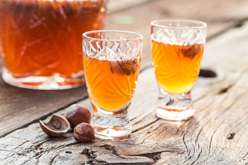 Homemade sweet liqueur with alcohol and hazelnuts - obrazy, fototapety, plakaty
