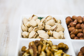 Bowls with nuts on a  wooden table