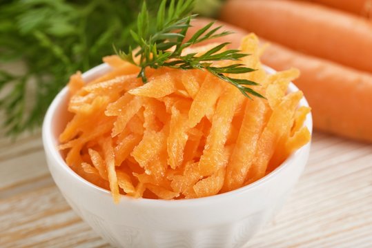 grated carrot on wooden background