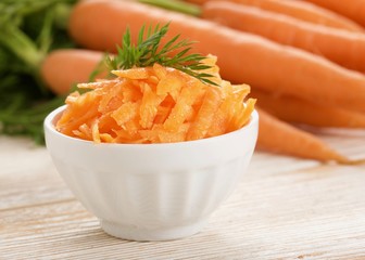 grated carrot on wooden background