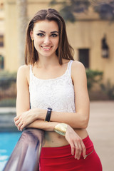 Vertical portrait of a smiling european woman with stylish bob cut and trendy make-up. Young adult female in white crop top and red skirt. Happiness concept