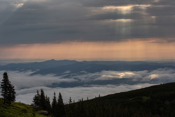Beautiful sunrise over mountains with storm clouds in background. Masivul Ceahlau, Romania.