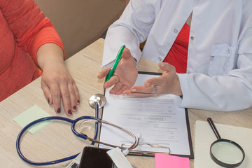 Female doctor holding application form while consulting patient