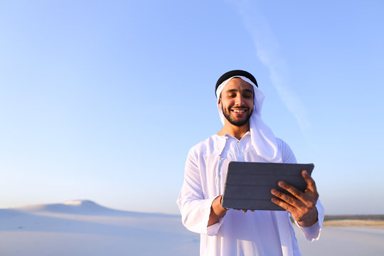Successful Arabian businessman holds in hands and uses tablet, s